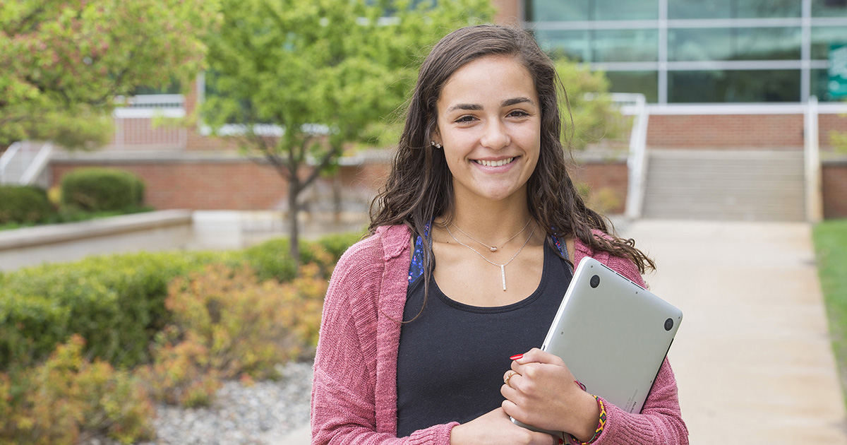 A student poses for a photo on campus.