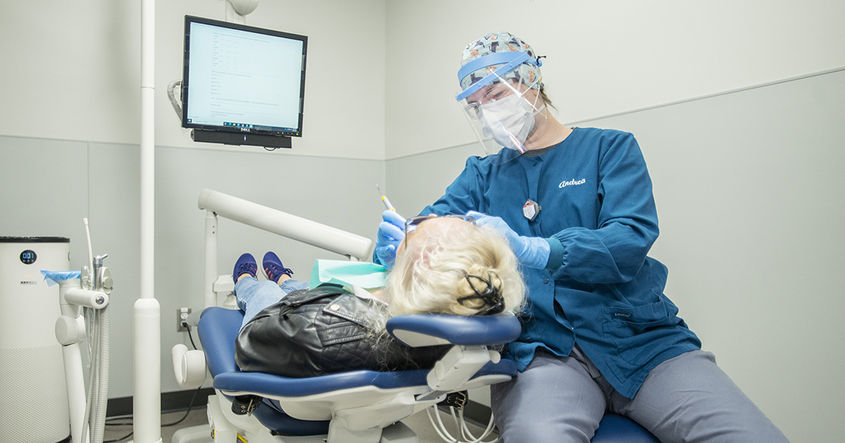 A  Dental Hygiene student works on a patient in the Dental Clinic.