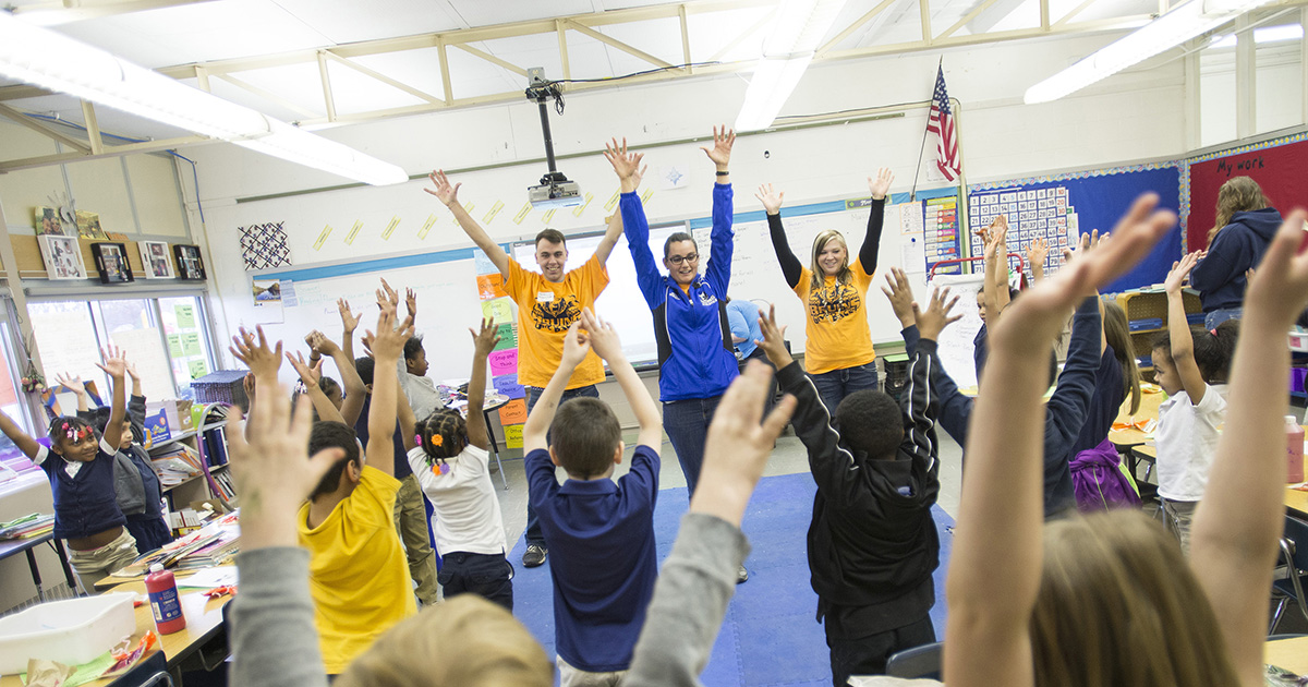 A KCC employee and students lead elementary school kids in stretches.