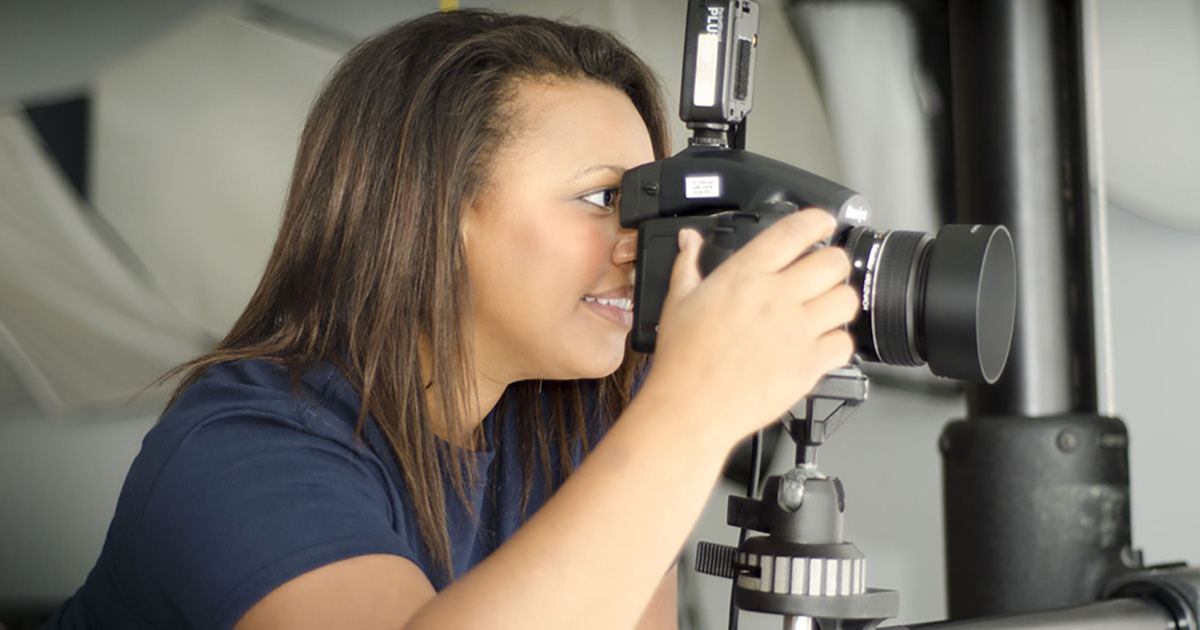 A female Photography students operates a camera.