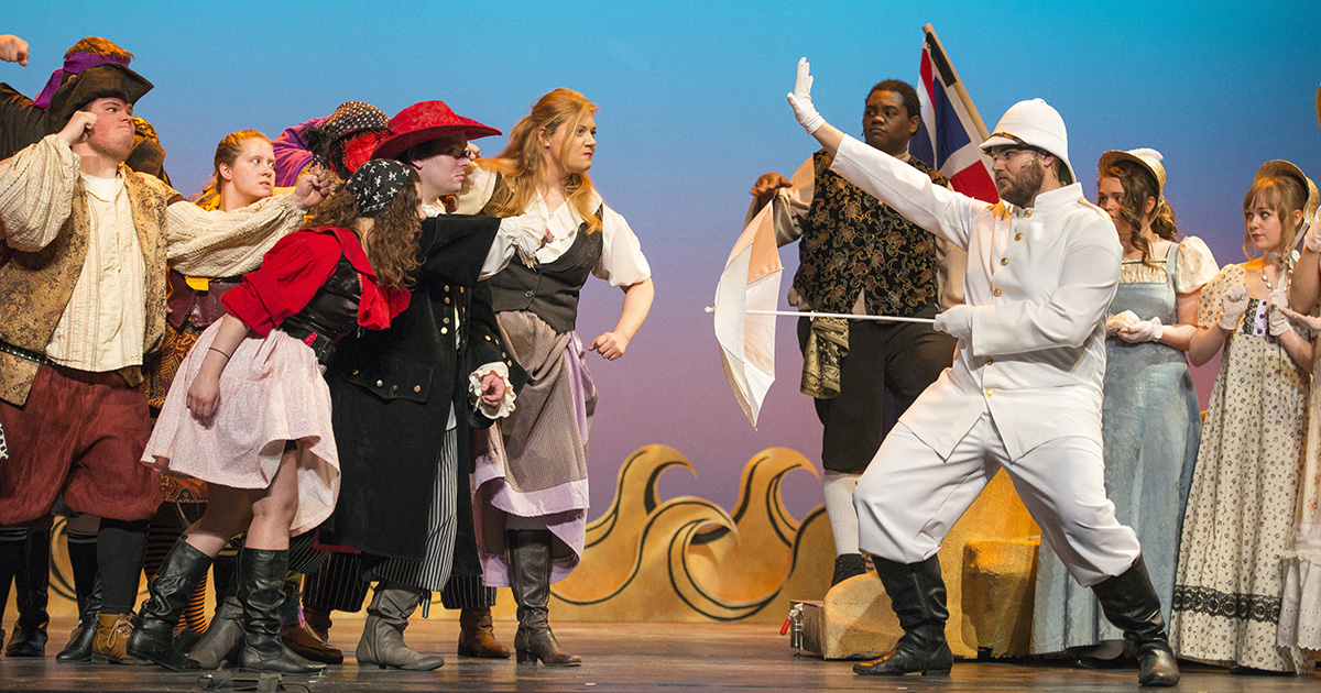 Actors dressed in various pirate costumes confront each other onstage during a rehearsal for "The Pirates of Penzance."