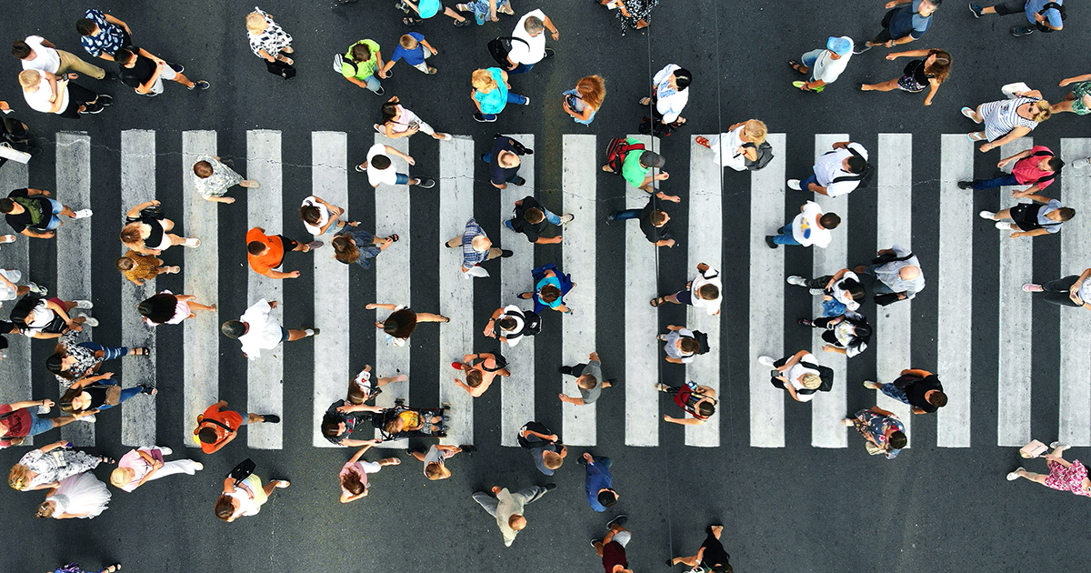 An overhead aerial view of people walking over a crosswalk.