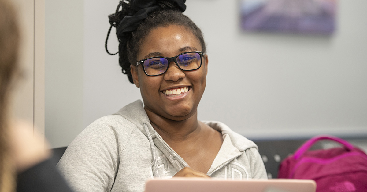 A Human Services student smiles in class.